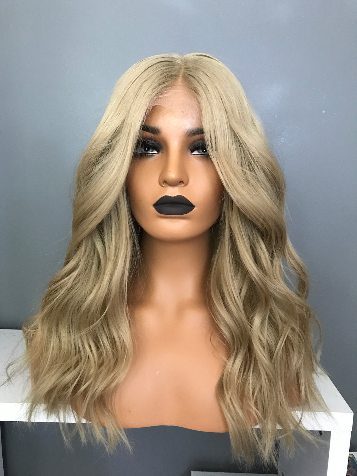 Model wearing blonde balayage 18-inch HD lace human hair wig in body wave texture – Nuola Wigs.