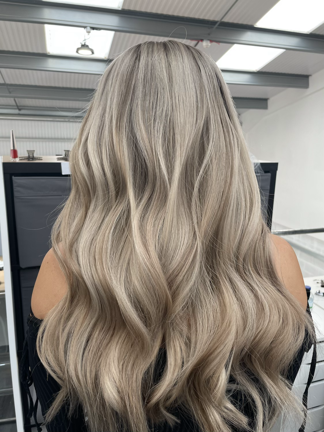 Model wearing blonde balayage 24-inch HD lace human hair wig in body wave texture – Nuola Wigs.