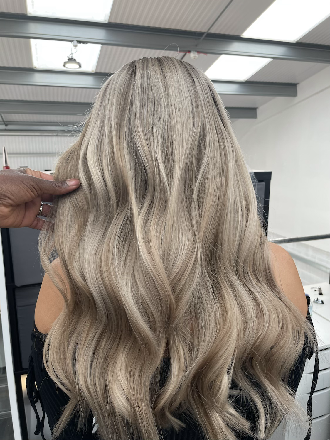 Model wearing blonde balayage 24-inch HD lace human hair wig in body wave texture – Nuola Wigs.