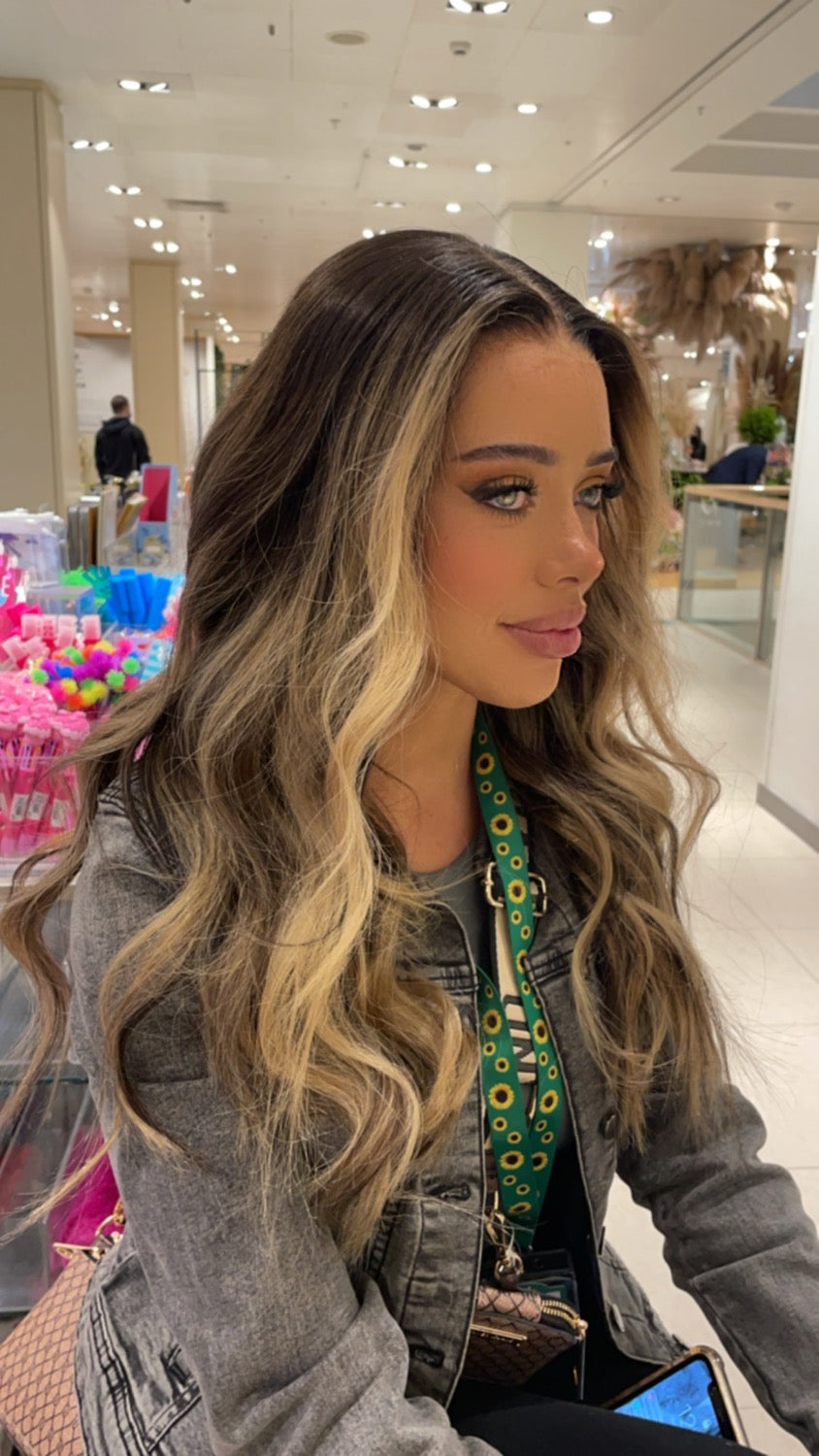 Model wearing brown balayage 22-inch HD lace human hair wig in body wave texture – Nuola Wigs.