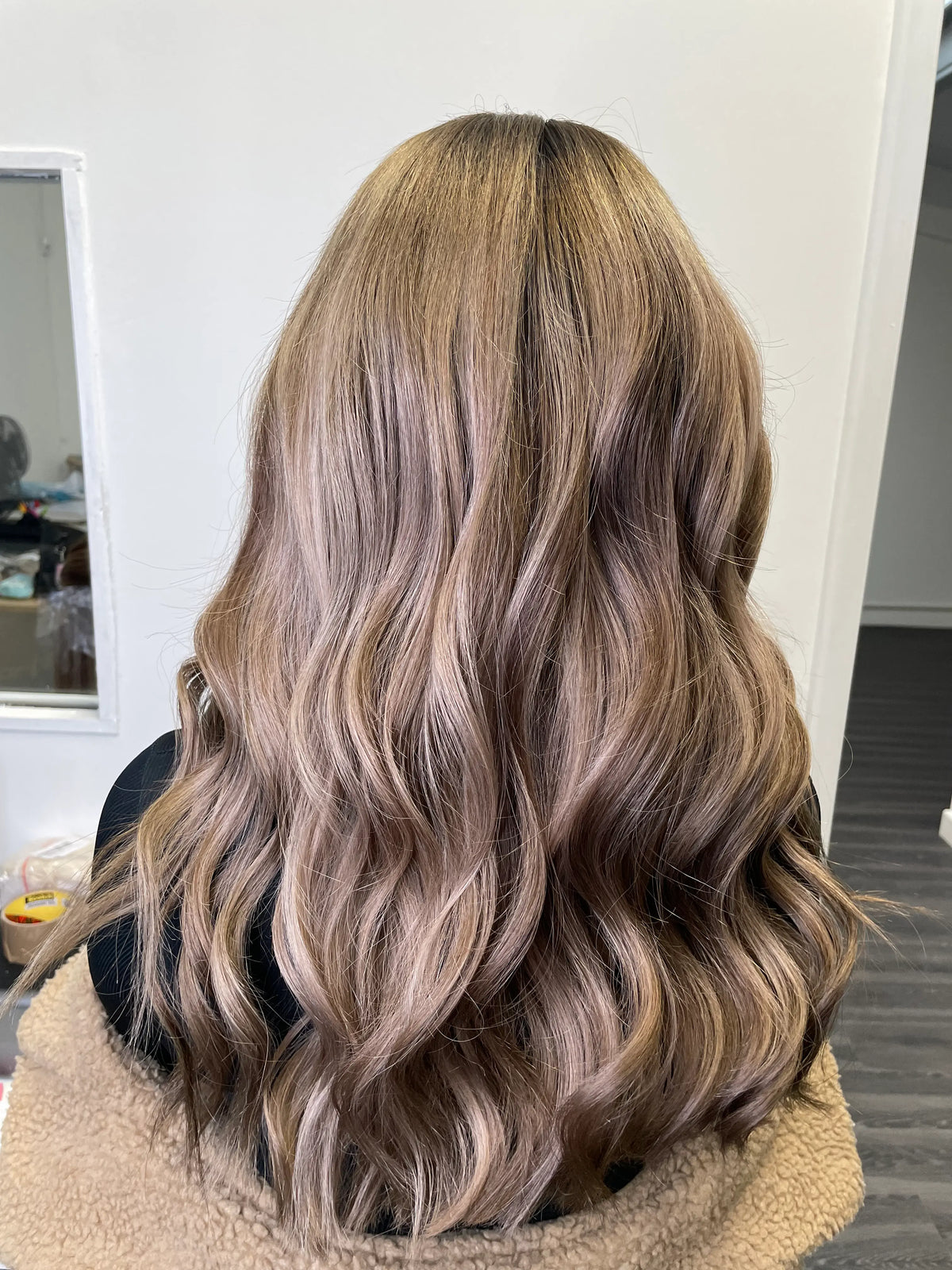 Model wearing brown balayage 22-inch HD lace human hair wig in body wave
texture – Nuola Wigs.