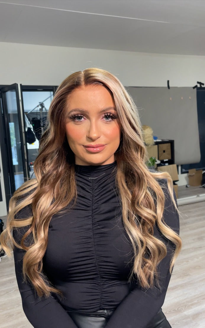 Model wearing brown balayage 26-inch HD lace human hair wig in body wave
texture – Nuola Wigs.