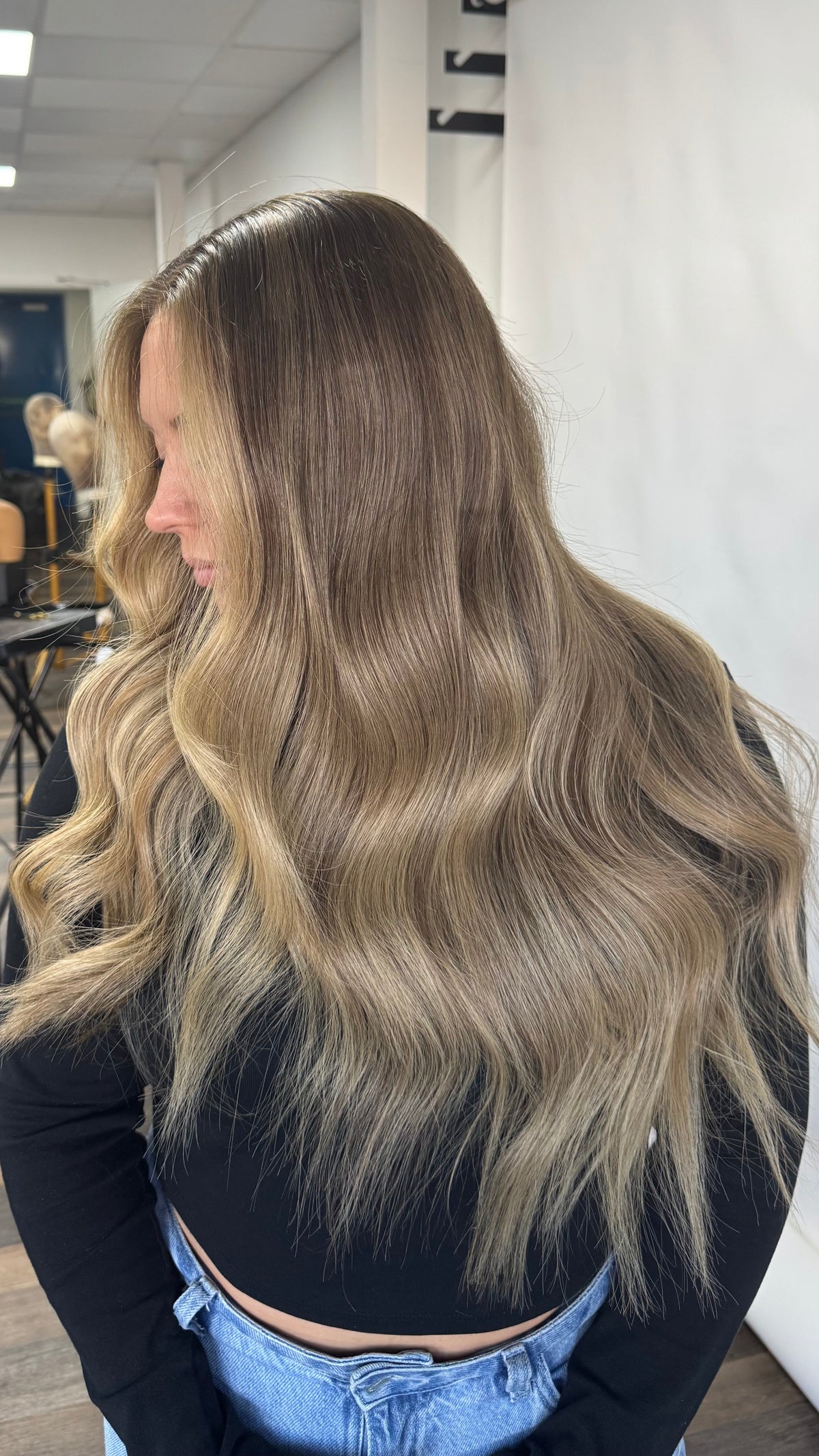 Model wearing blonde balayage 22-inch HD lace human hair wig in body wave
texture – Nuola Wigs.