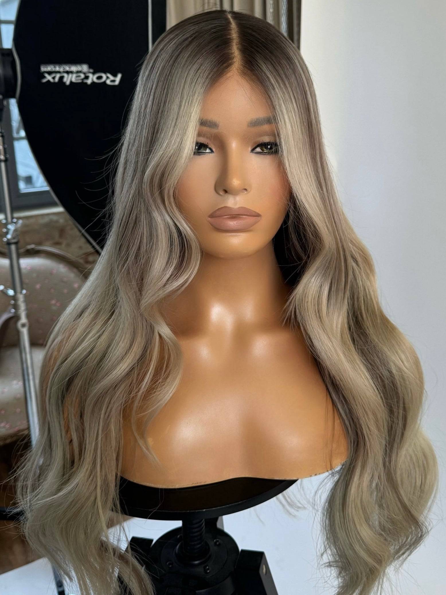 Model wearing blonde balayage 24-inch HD lace human hair wig in body wave
texture – Nuola Wigs.