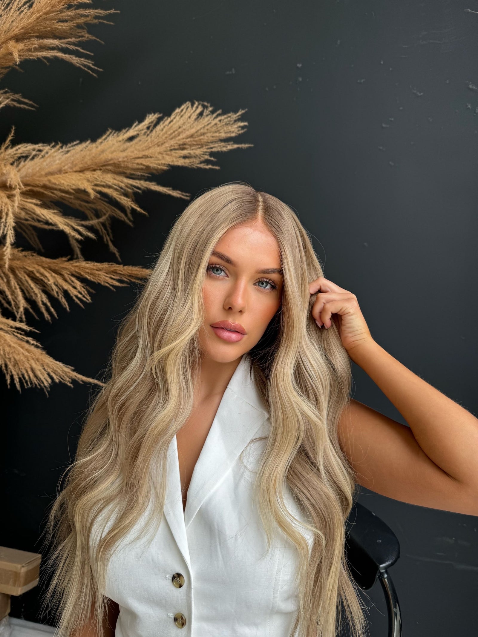 Model wearing blonde balayage 26-inch HD lace human hair wig in body wave
texture – Nuola Wigs.