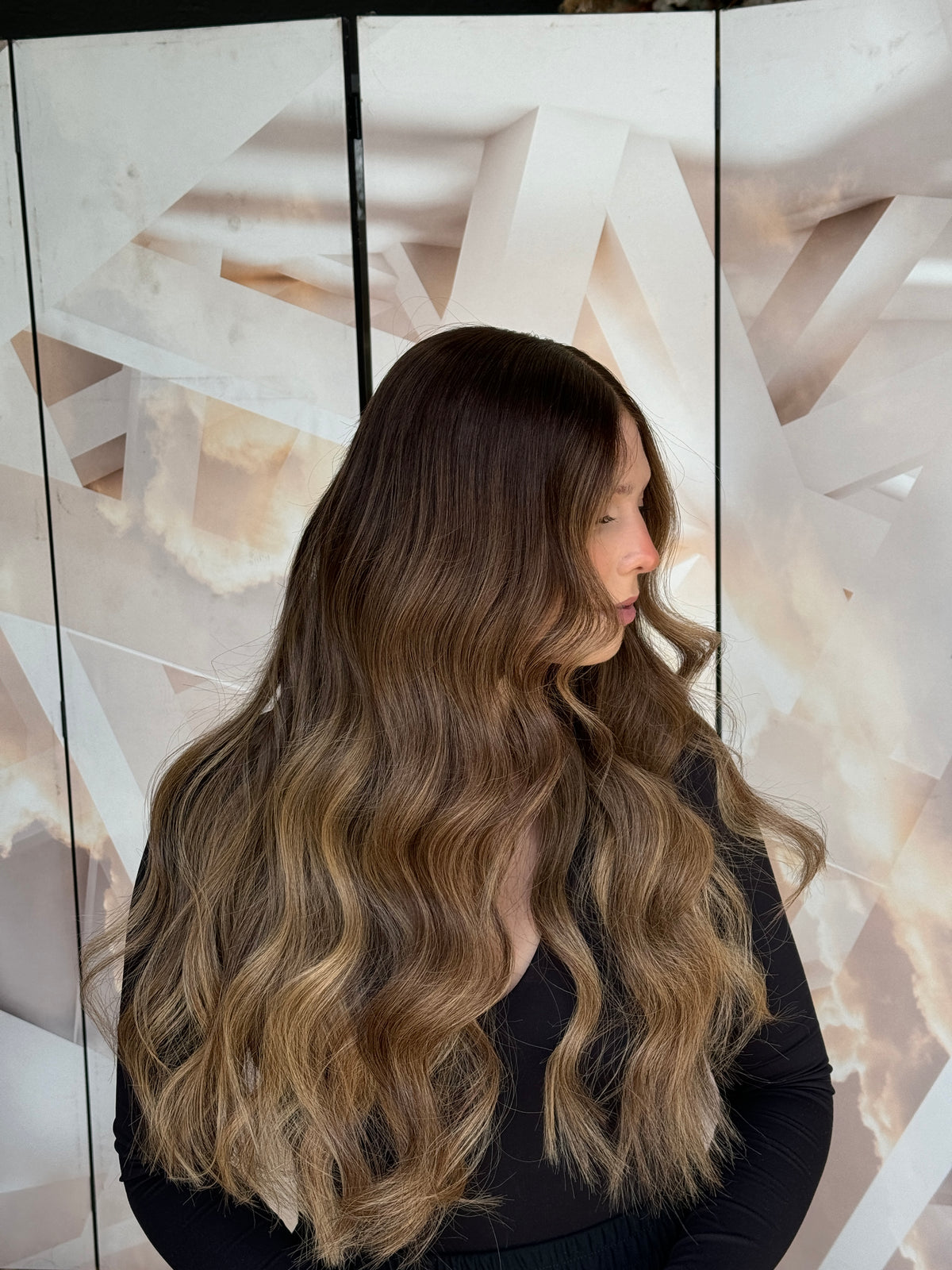 Model wearing brown balayage 24-inch HD lace human hair wig in body wave
texture – Nuola Wigs.