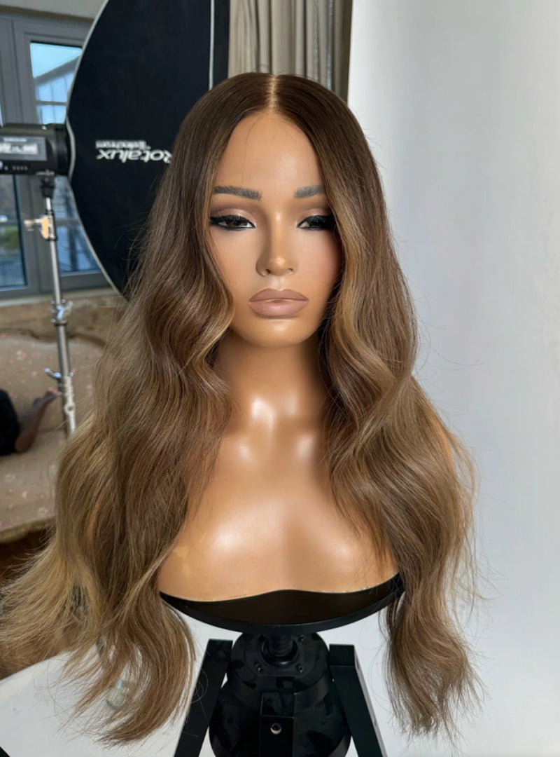 Model wearing brown balayage 24-inch HD lace human hair wig in body wave
texture – Nuola Wigs.
