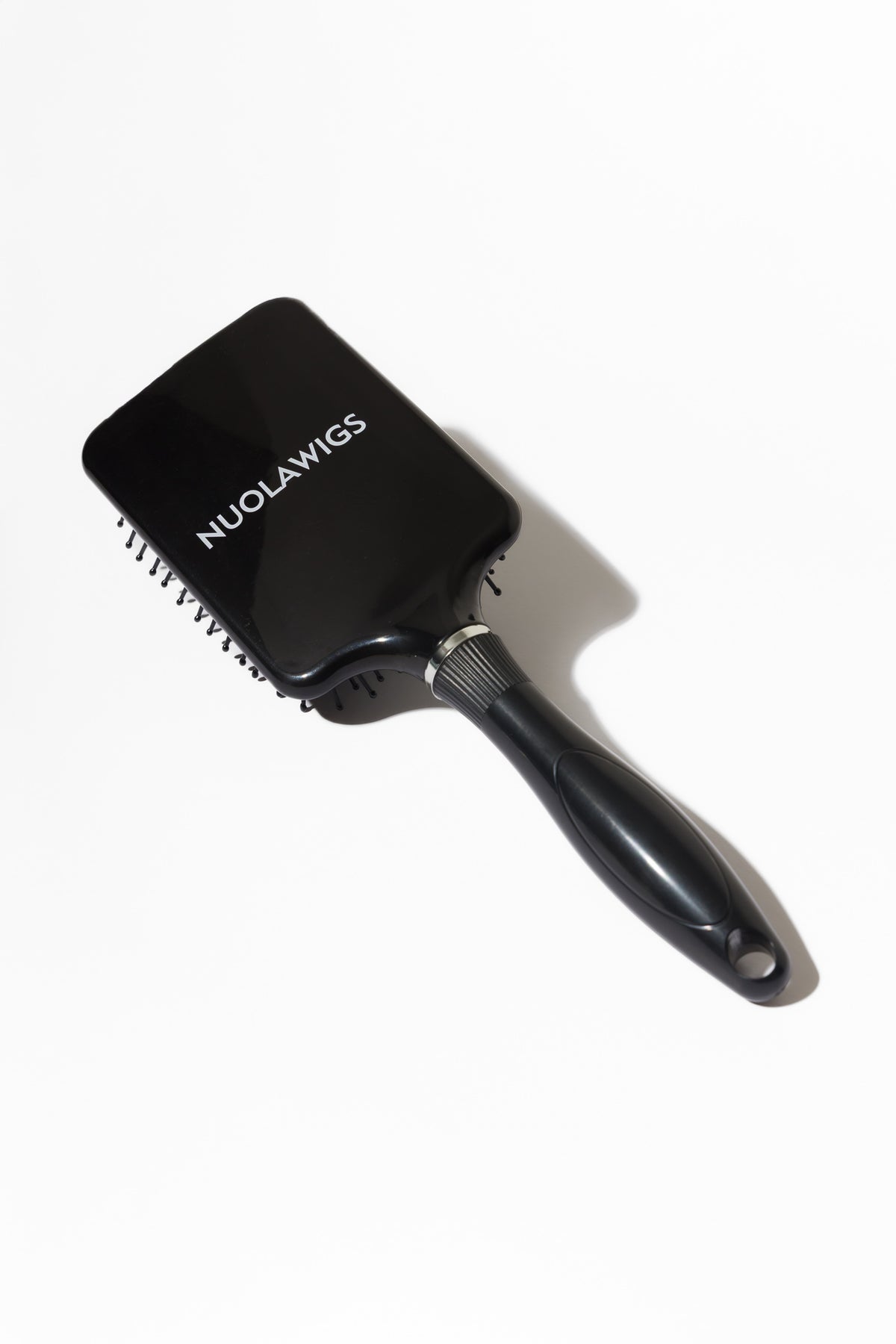 Model using soft bristle wig head brush to gently detangle and maintain wig fibres – Nuola Wigs.