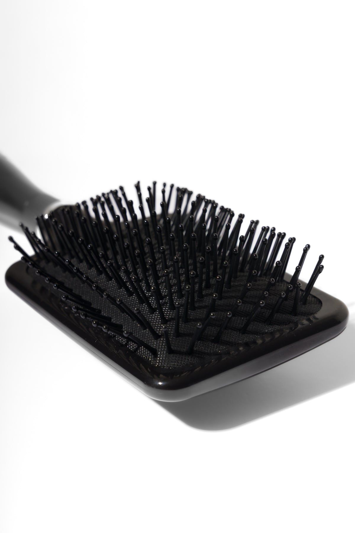 Model using soft bristle wig head brush to gently detangle and maintain wig fibres – Nuola Wigs.