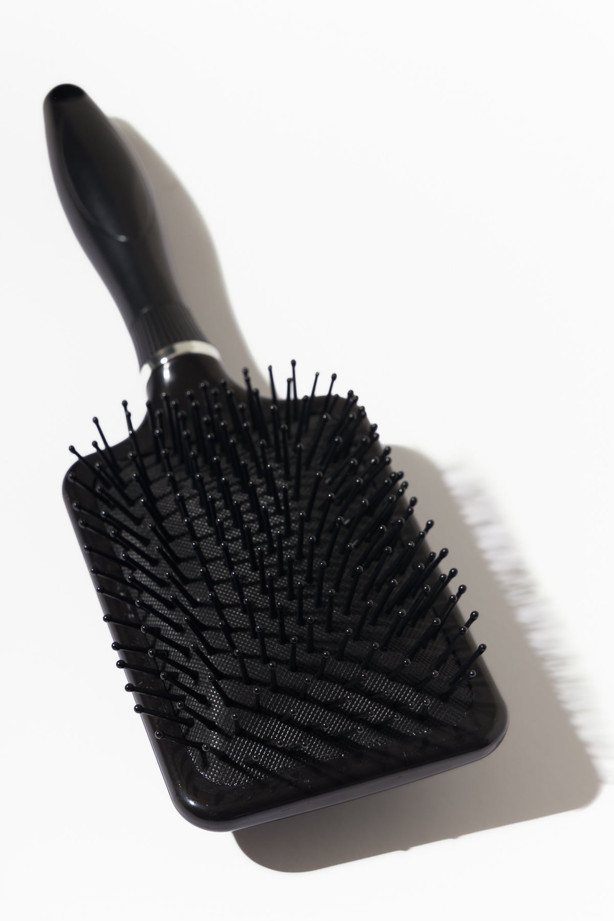 Model using soft bristle wig head brush to gently detangle and maintain wig fibres – Nuola Wigs.